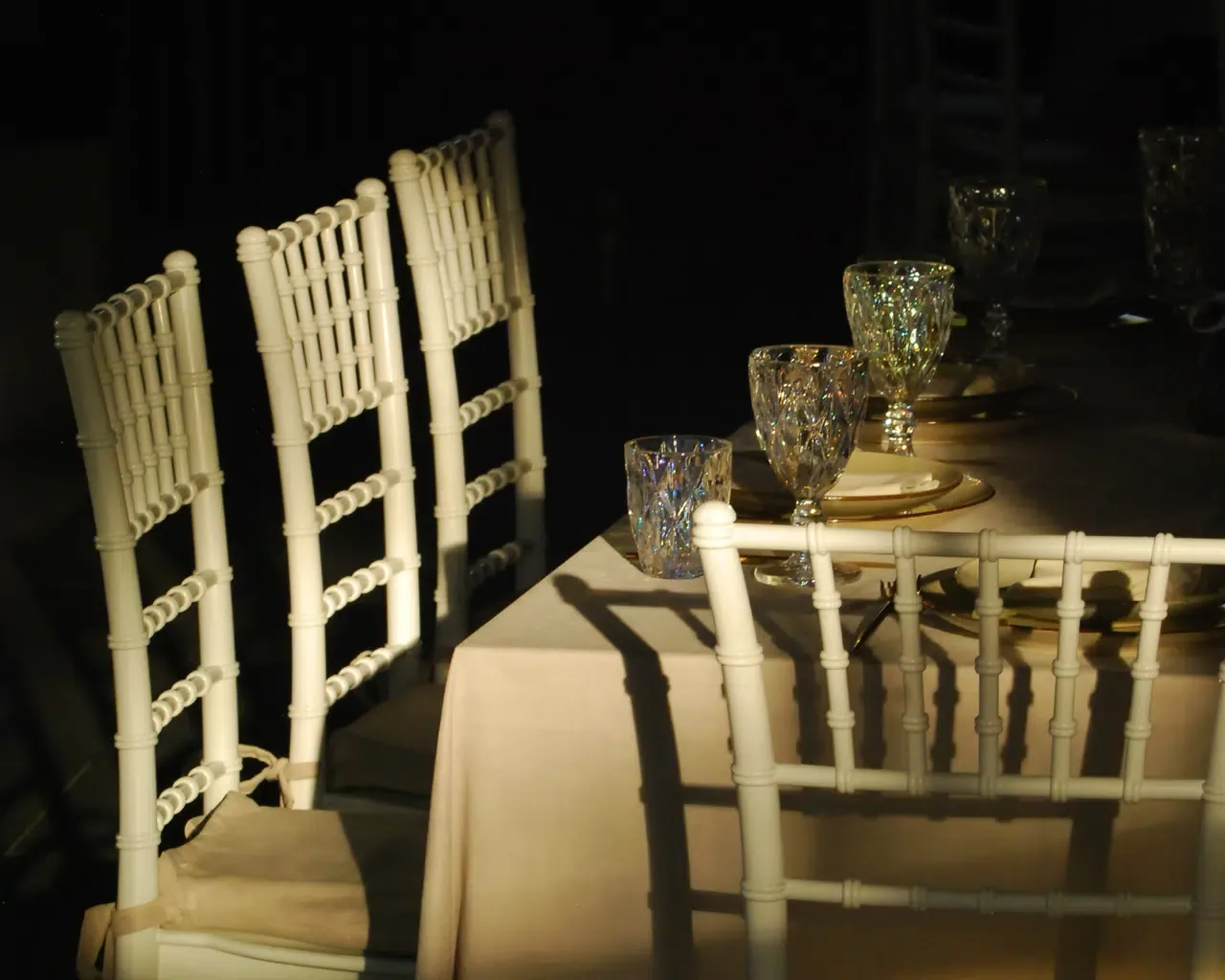 Espacio representativo del hotel: Una mesa de banquete está preparada con asientos blancos y cristalería decorativa.