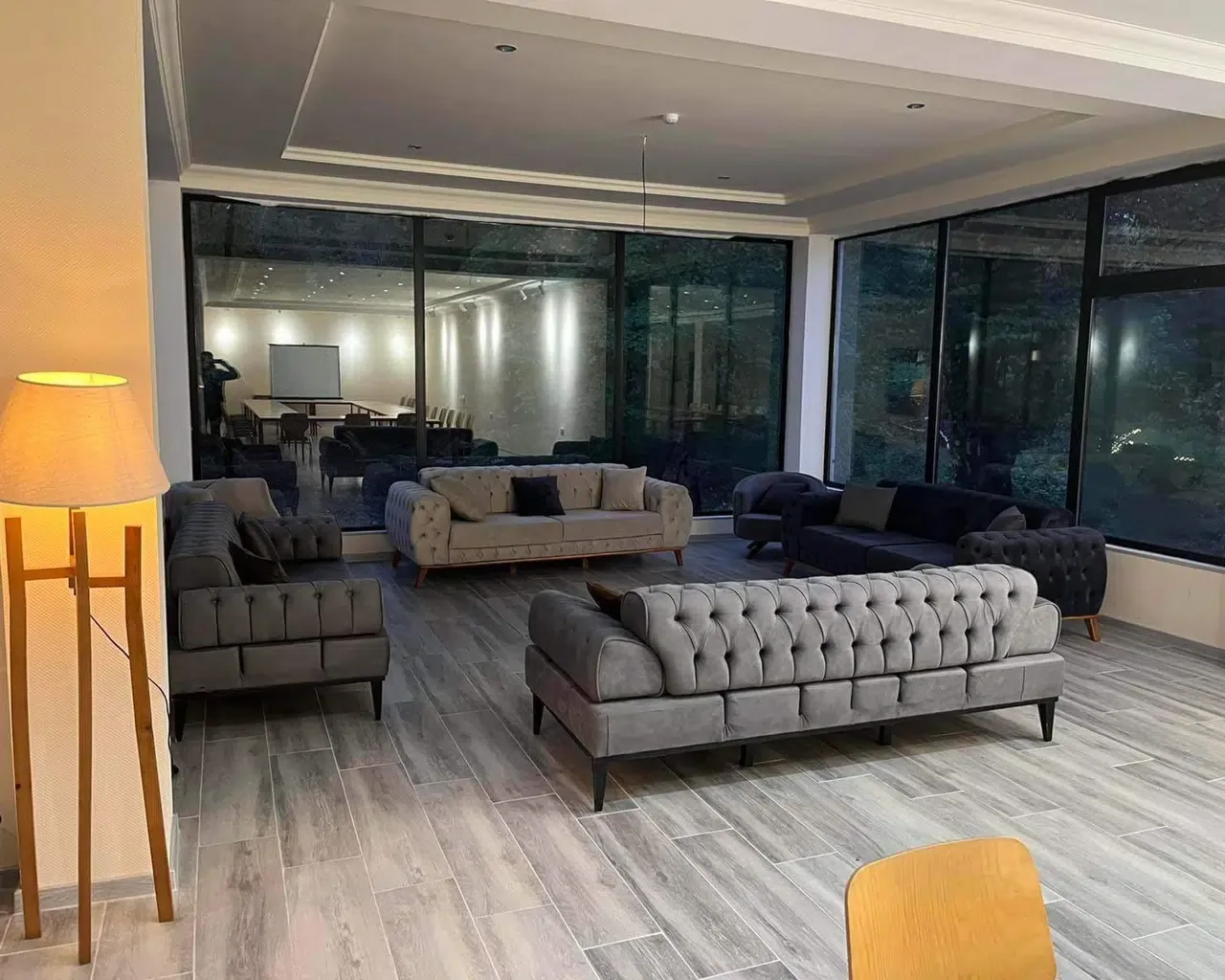Espacio representativo del hotel: Una amplia sala de estar con asientos dispuestos alrededor de una mesa baja.