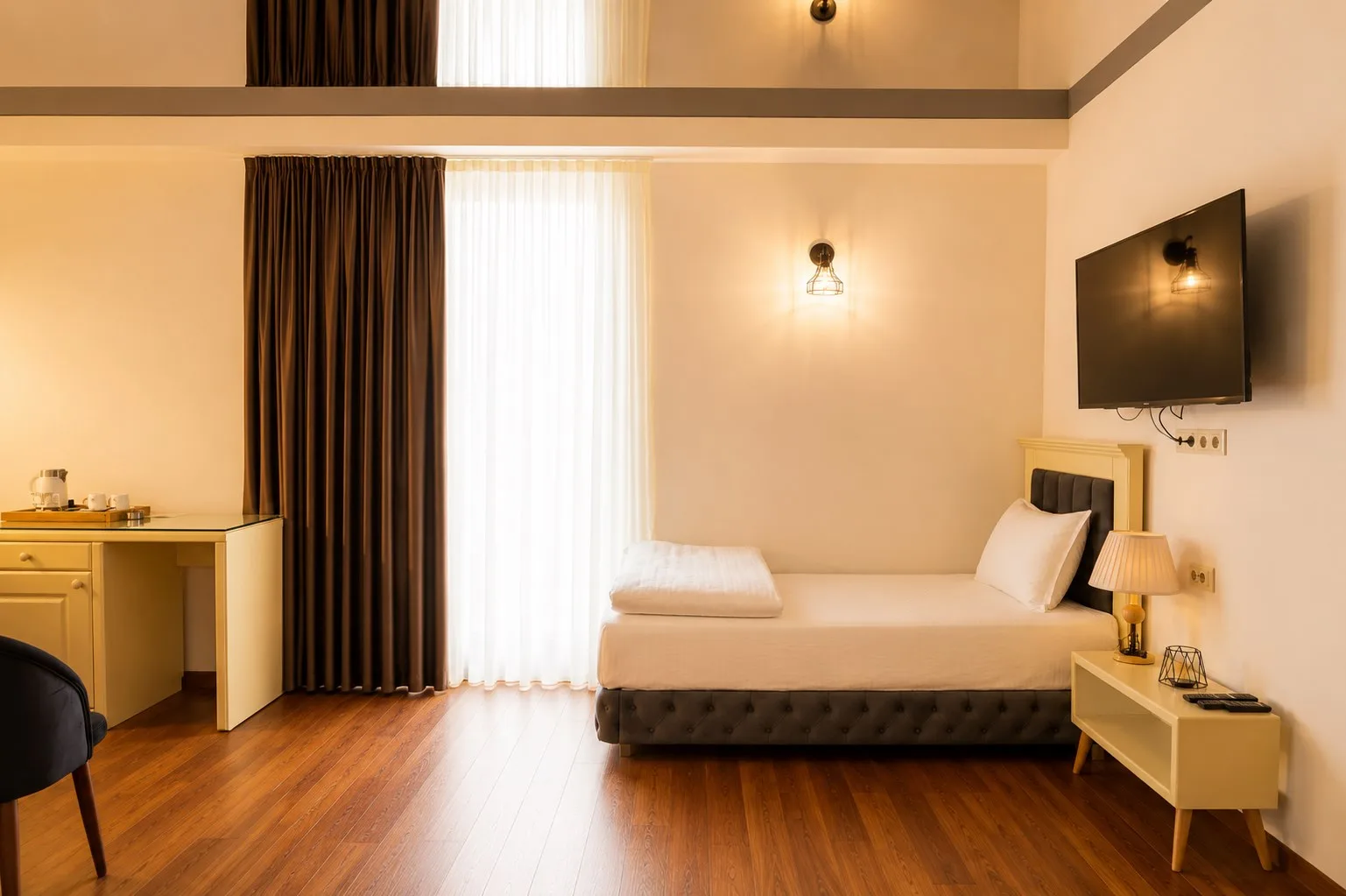 Espacio representativo del hotel: Un dormitorio de hotel con una cama junto a una ventana luminosa con cortinas.