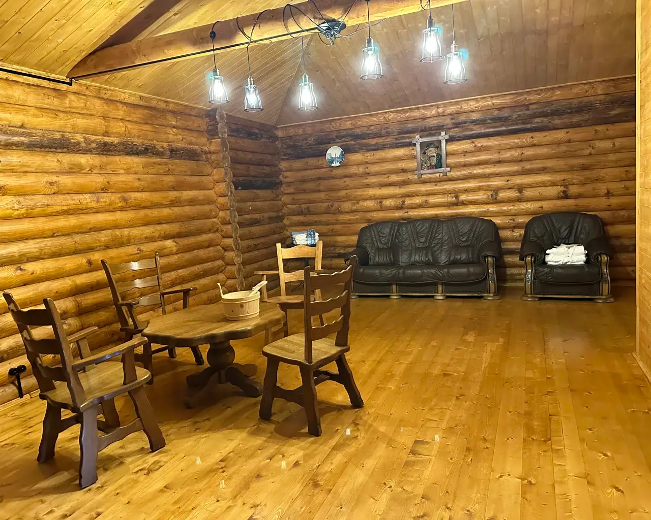 Espacio representativo del hotel: Una sala revestida de madera con asientos, mesas y luces colgantes.