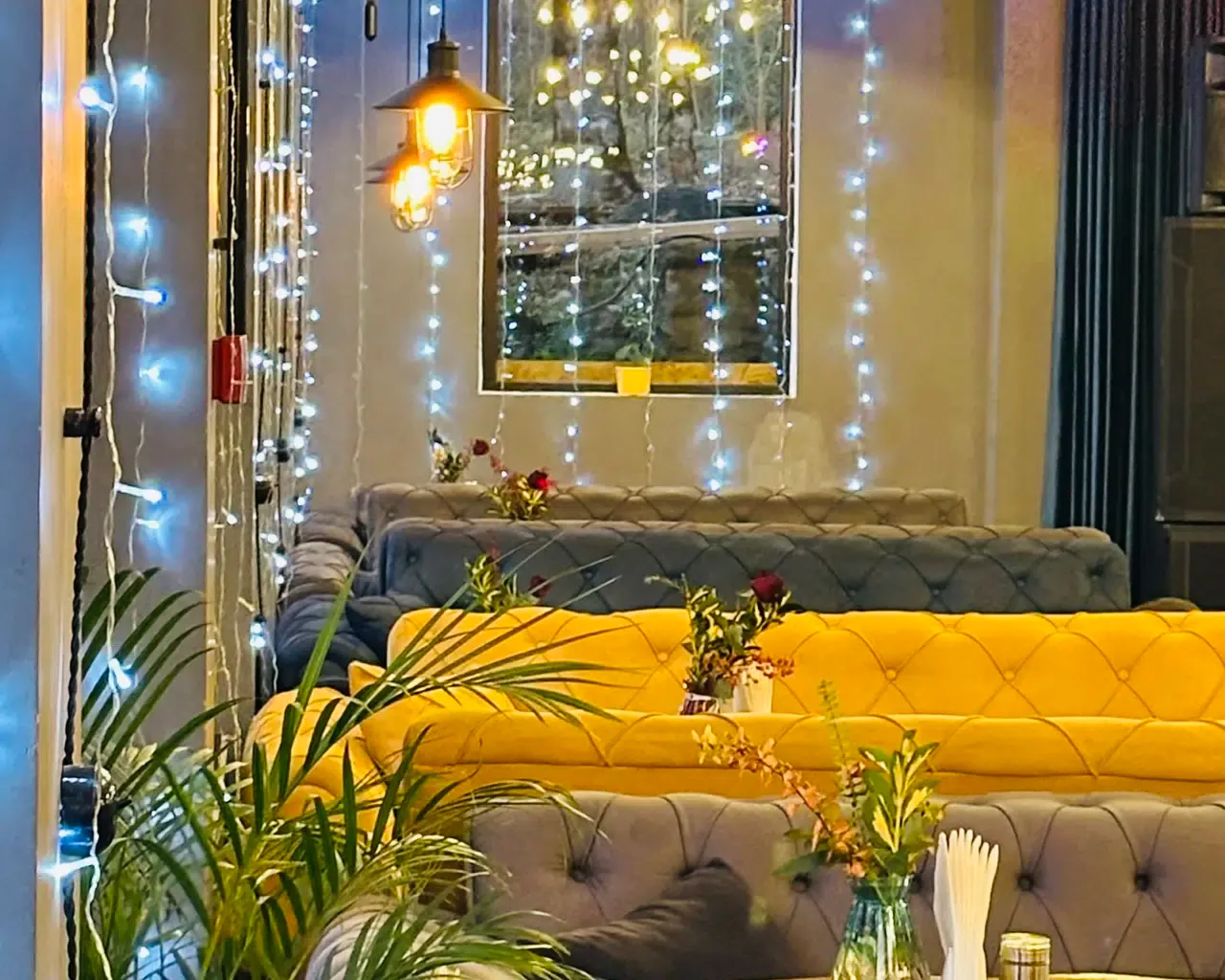 Espacio representativo del hotel: Una zona de estar con bancos tapizados de colores y luces decorativas.