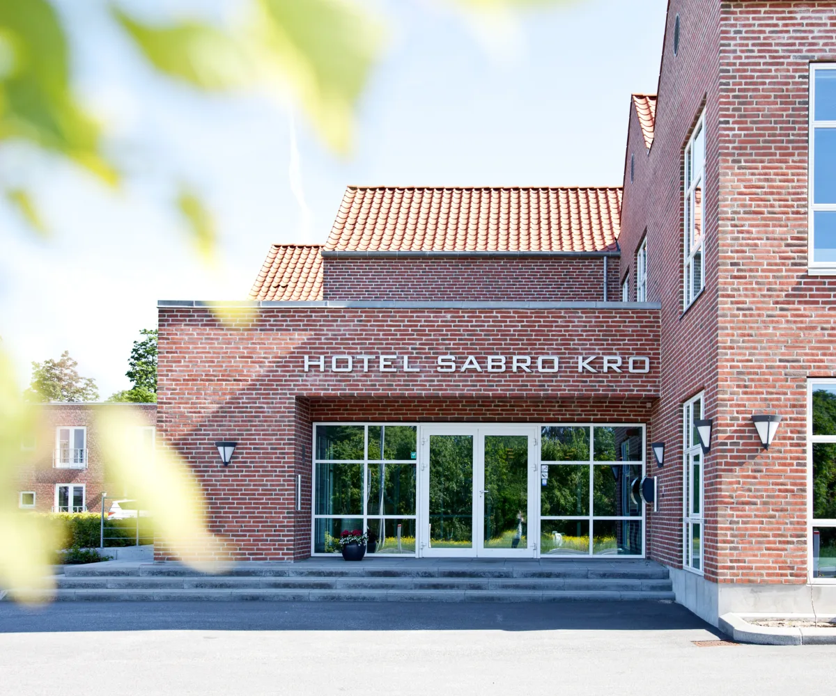 Representative hotel space: A brick hotel entrance with glass doors and windows.