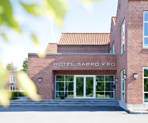Representative hotel space: A brick hotel entrance with glass doors and a tiled roof.