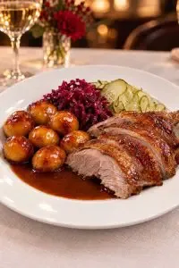 Representative hotel space: A plated meal features sliced roast meat, potatoes, and vegetables.