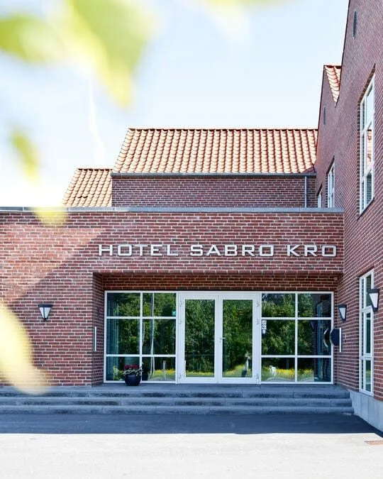 Representative hotel space: A brick hotel entrance with glass doors and large windows.