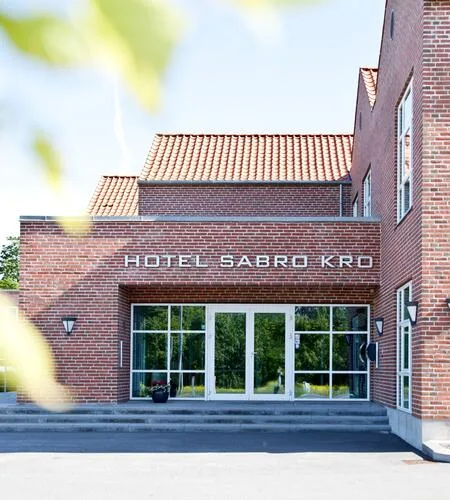 Espacio representativo del hotel: La entrada del hotel tiene una fachada de ladrillo y grandes puertas de vidrio.