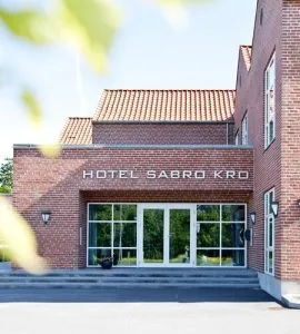 Representative hotel space: The brick hotel entrance has glass doors beneath a tiled roof.