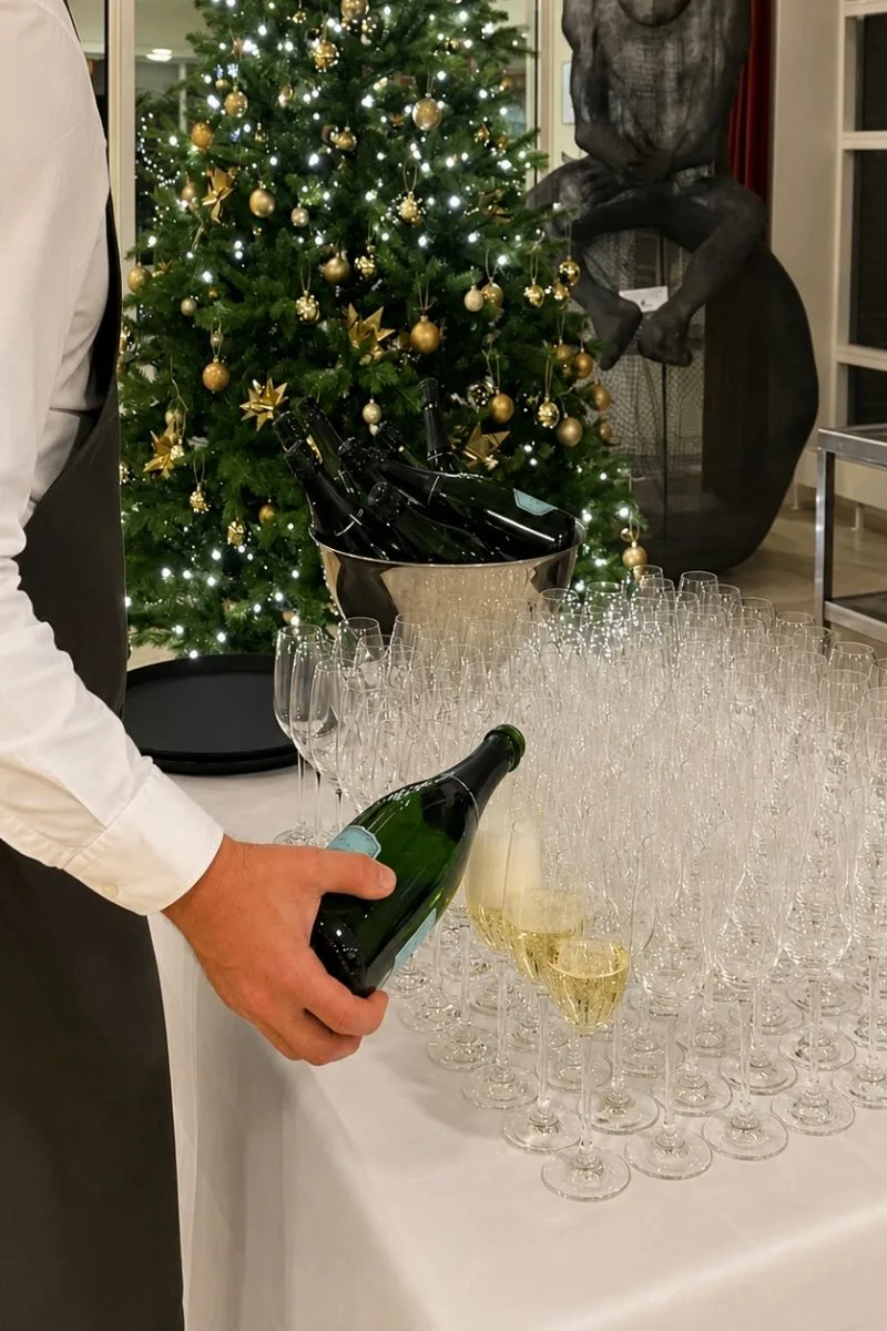Representative hotel space: A festive reception table is set with glasses beside a decorated Christmas tree.