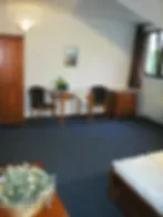 Representative hotel space: A small lounge area with seating and a table sits beside a wooden door.