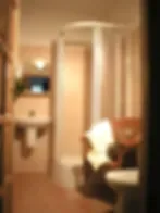 Representative hotel space: A softly lit bathroom with a sink and shower.