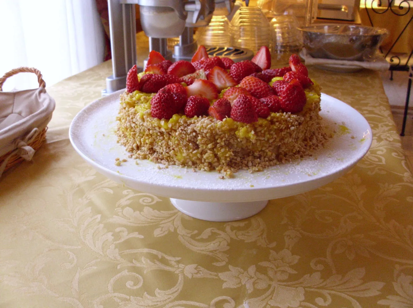 Representative hotel space: A strawberry-topped cake sits on a serving plate on a patterned tablecloth.
