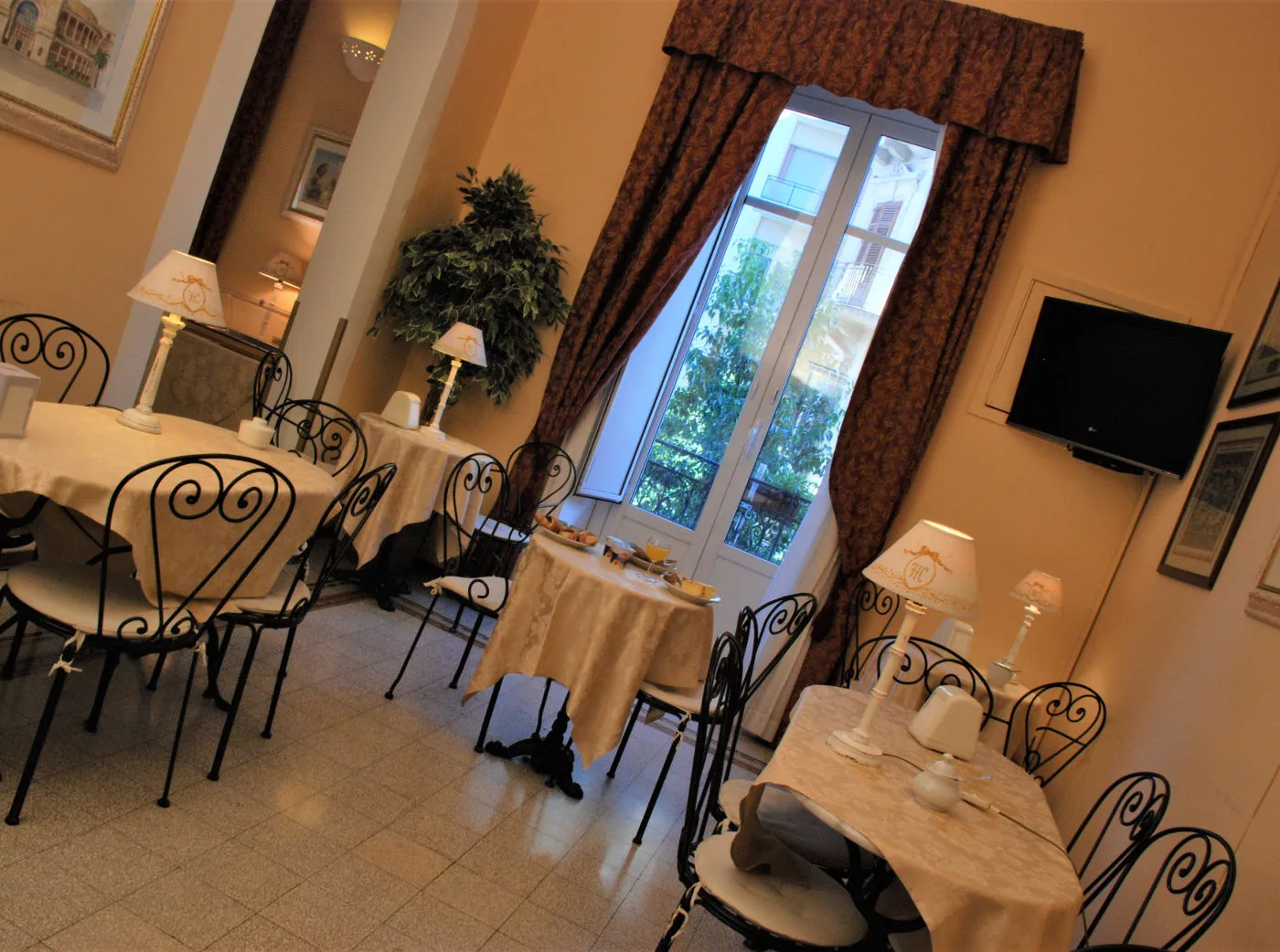 Representative hotel space: A dining room with tables and chairs arranged beside a large window.