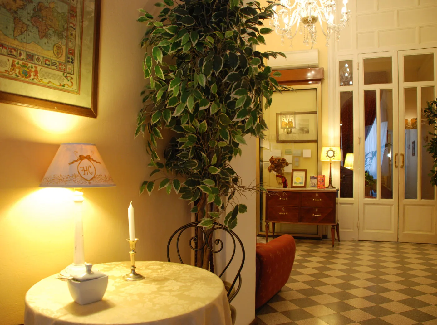 Representative hotel space: A warmly lit interior features a round table beside a large leafy plant.