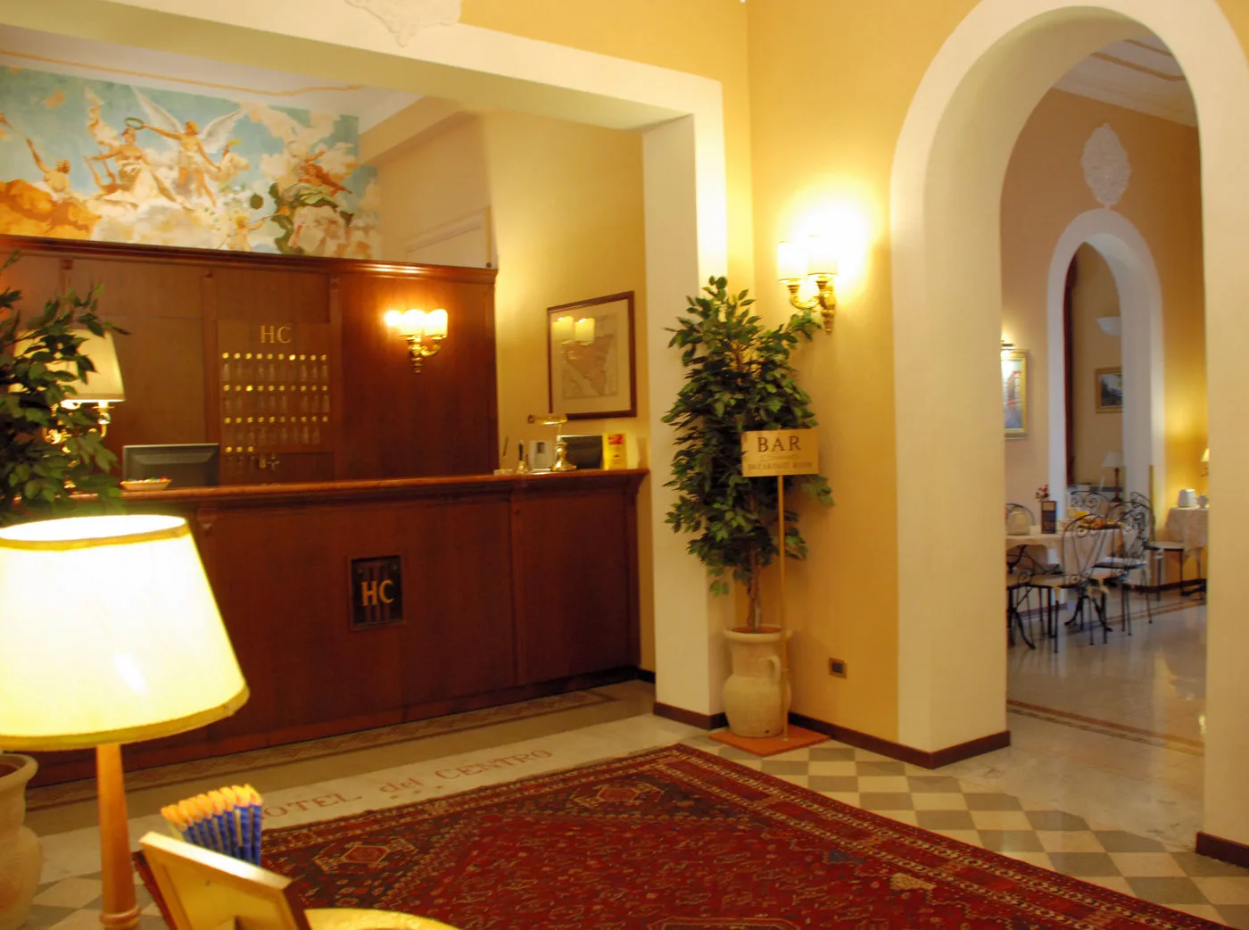 Representative hotel space: A hotel reception desk stands beside an arched passage to a dining area.