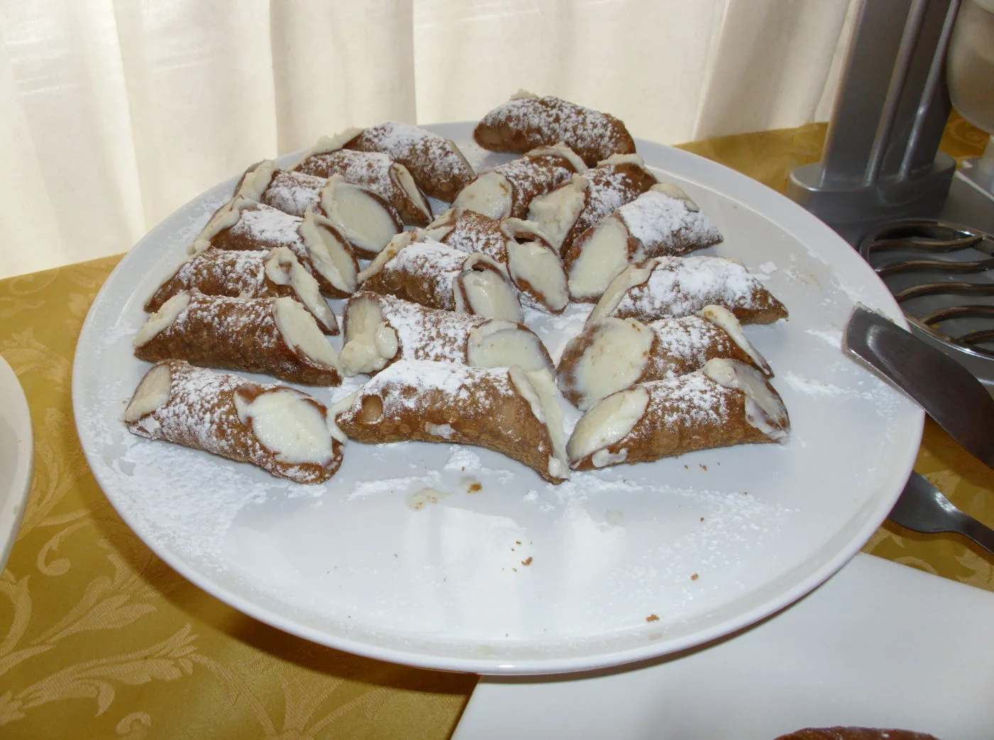 Representative hotel space: A plate of powdered pastries filled with cream and topped with sliced almonds.