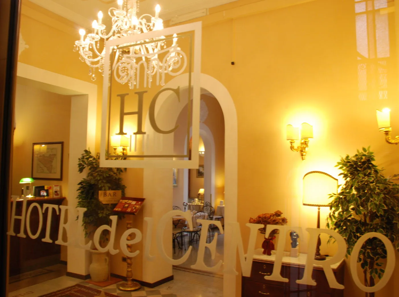Representative hotel space: Hotel lobby with warm lighting, a chandelier, and decorative lettering on glass.