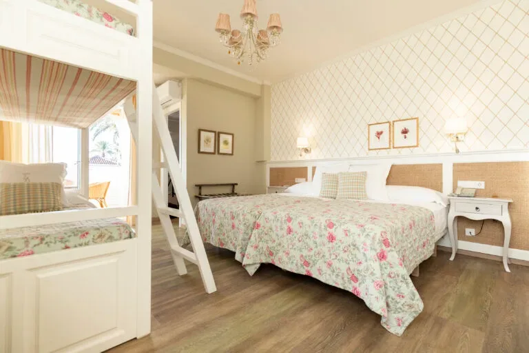 Representative hotel space: A bedroom with floral bedding, a bunk bed, and a chandelier.