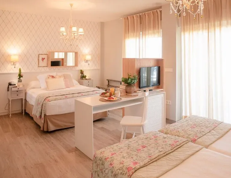 Representative hotel space: A bright bedroom with a bed, a desk, and a television.