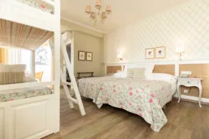 Representative hotel space: A bedroom with two beds, bedside tables, and light patterned bedding.
