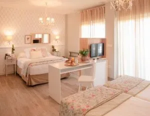 Representative hotel space: A bright bedroom with a bed, seating, and large windows.