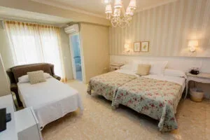 Representative hotel space: A bedroom with two beds, bedside lamps, and a window with curtains.