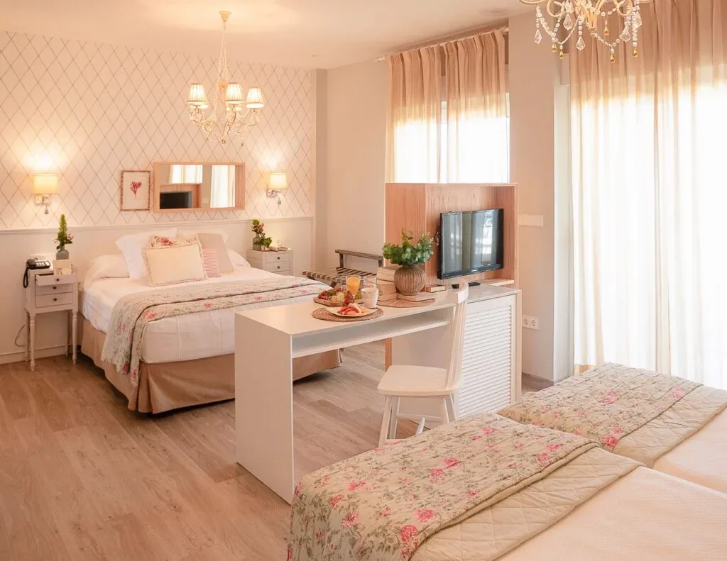 Representative hotel space: A bedroom with two beds, a television, and a small desk.