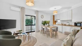 A bright open-plan living and dining area with seating beside a table.