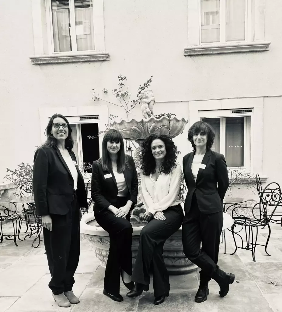 Espacio representativo del hotel: Cuatro personas posan junto a una fuente en un patio pavimentado.