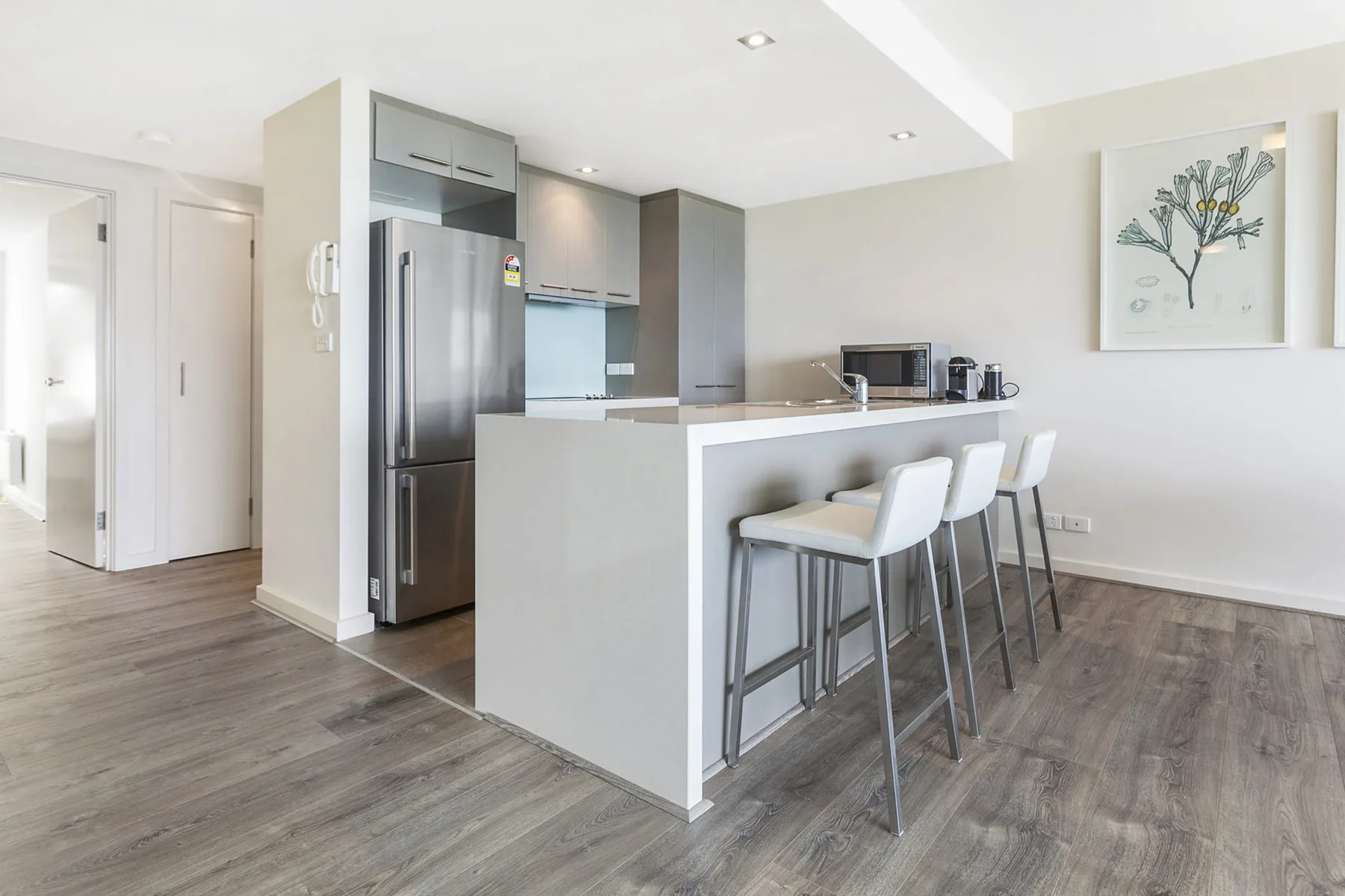 A bright kitchen with a breakfast bar and seating.