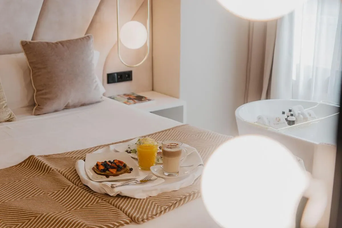 Representative hotel space: A bedroom with a breakfast tray on the bed and a bathtub by the window.