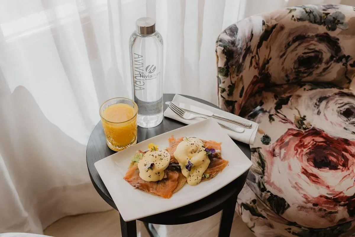 Representative hotel space: A meal with juice and water is set beside a floral upholstered seat.