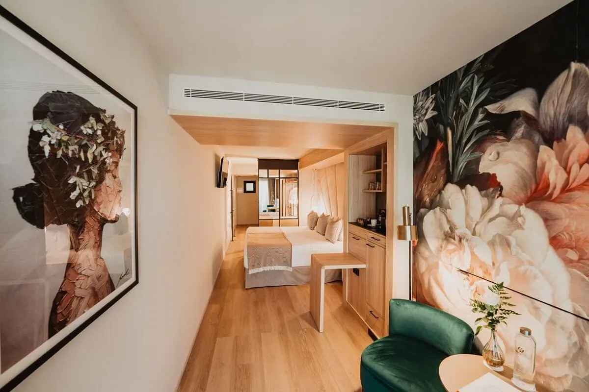 Representative hotel space: A hotel room with a bed, wood furnishings, and large floral wall art.