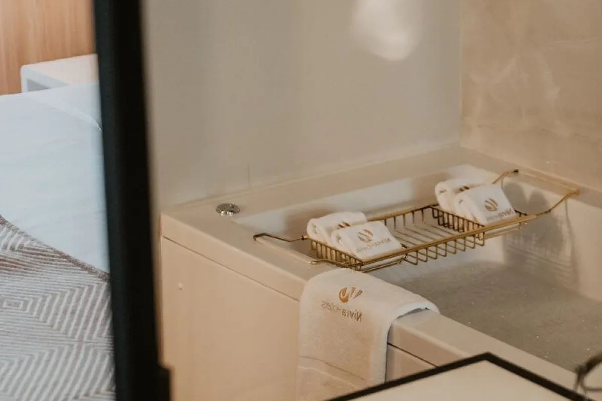 Representative hotel space: A bathroom vanity with folded towels on a metal rack beside the sink.