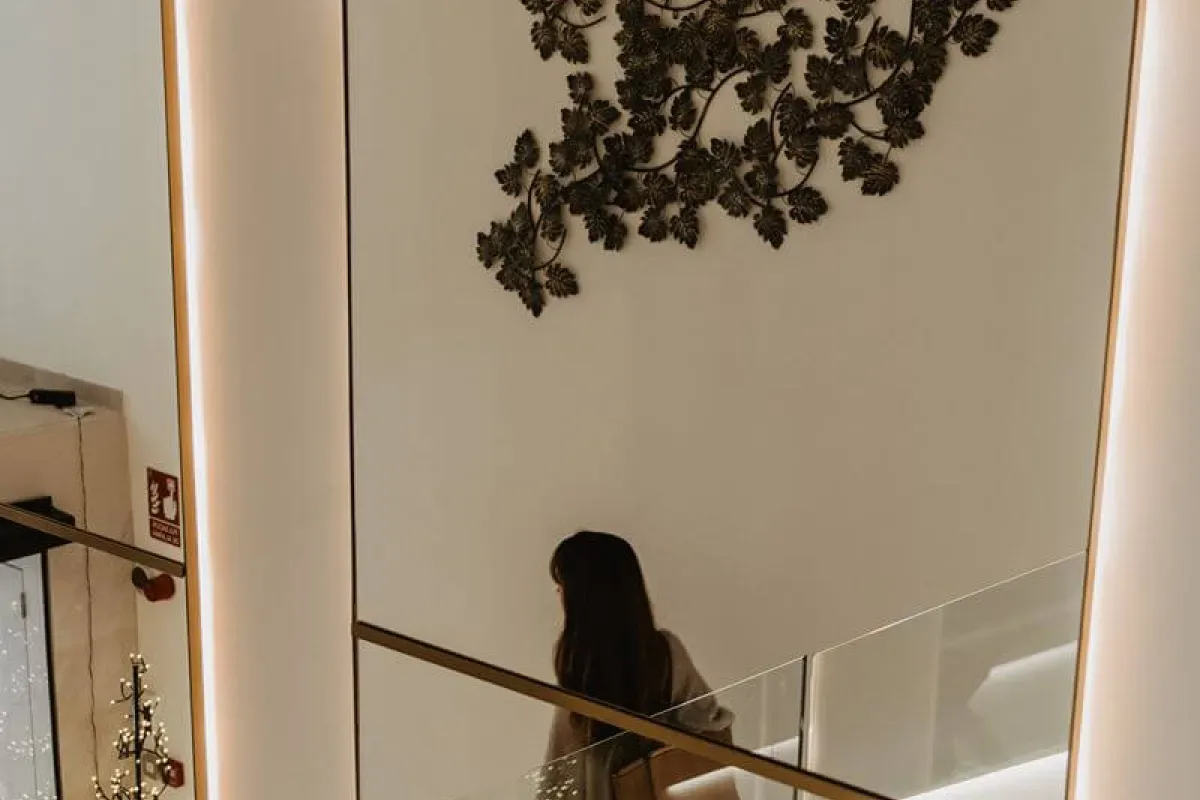Representative hotel space: An indoor staircase with glass railings and decorative metal wall art.