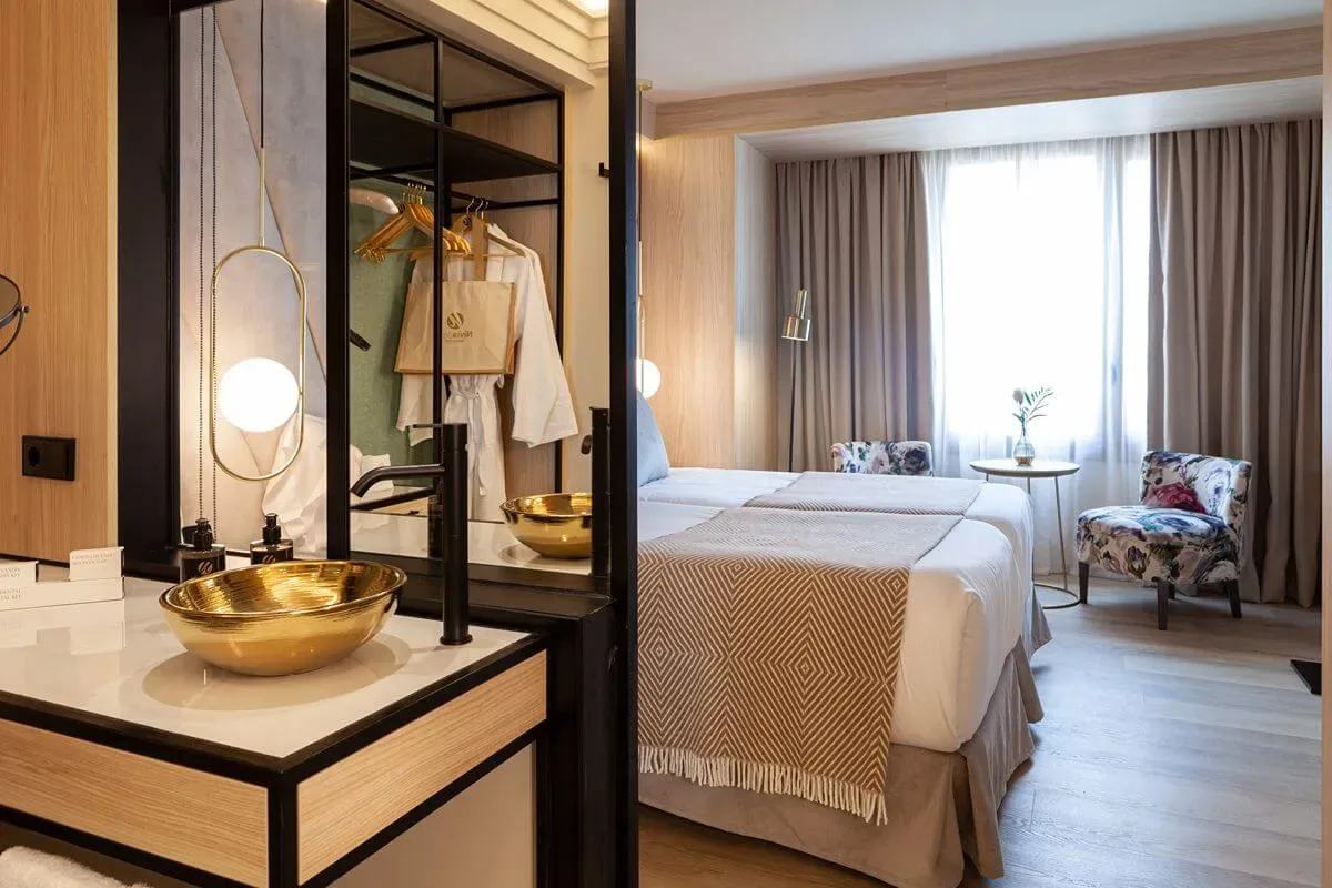 Representative hotel space: A bedroom with two beds, a vanity, and a seating area by the window.