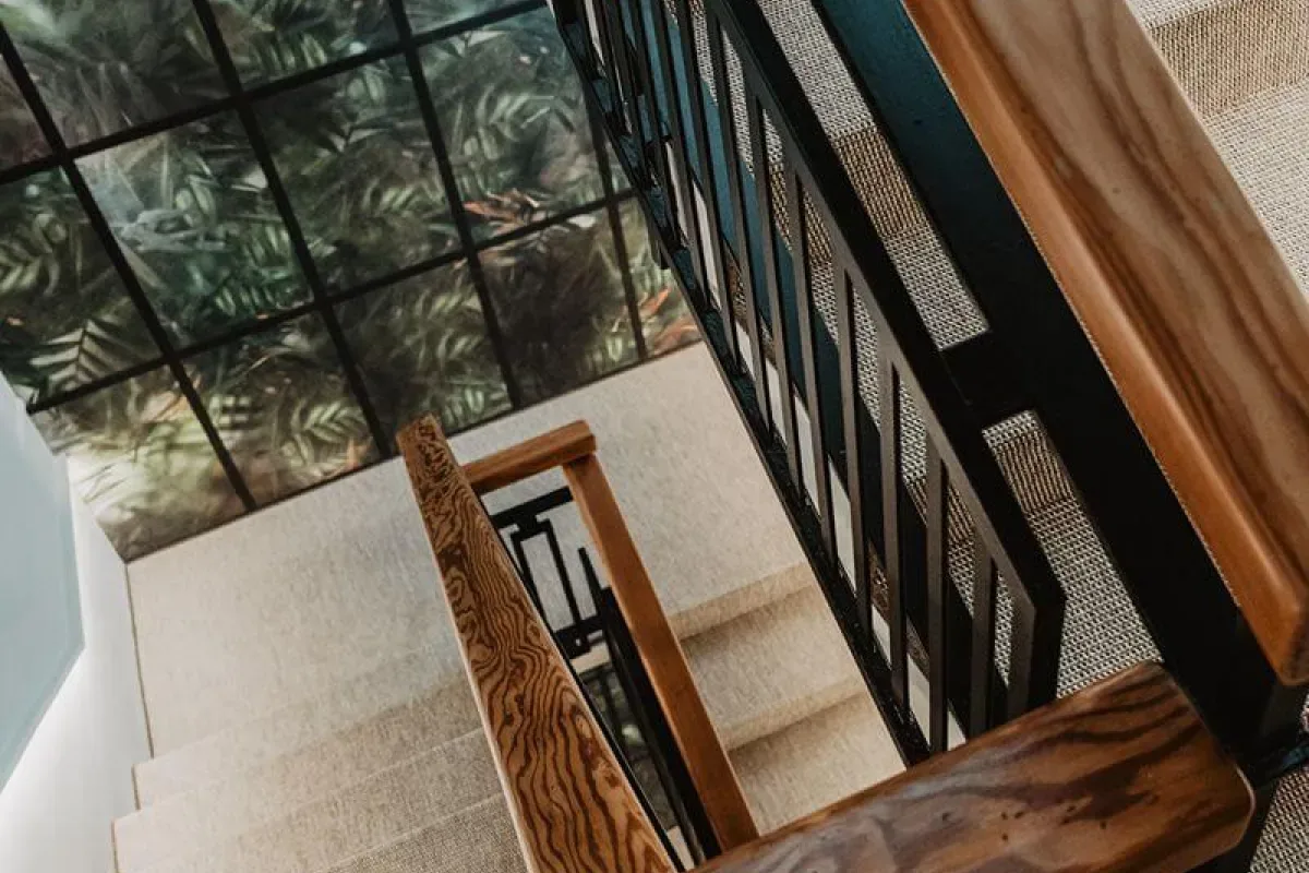 Representative hotel space: An interior staircase with wooden handrails and a glass ceiling above.