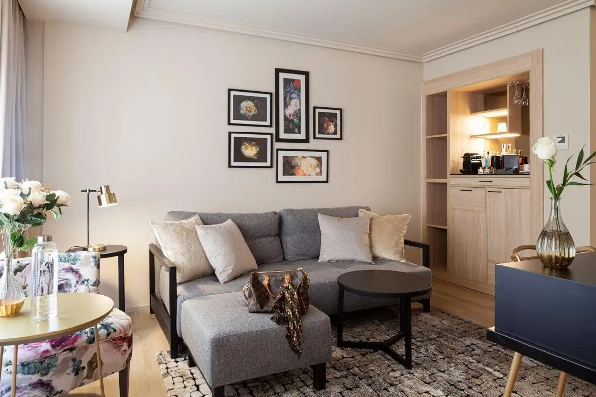Representative hotel space: A living room with a gray sectional sofa, coffee table, and framed artwork.