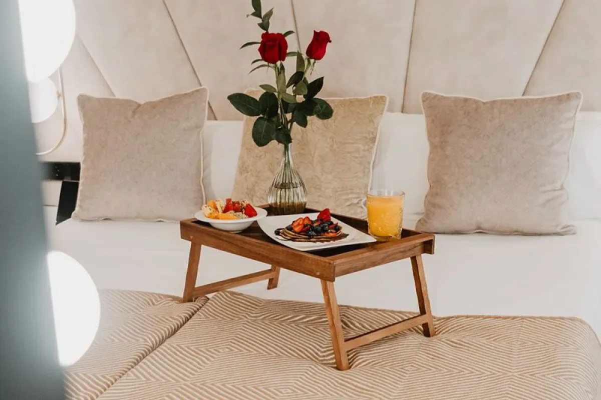 Representative hotel space: A breakfast tray with fruit, juice, and flowers sits on a bed.