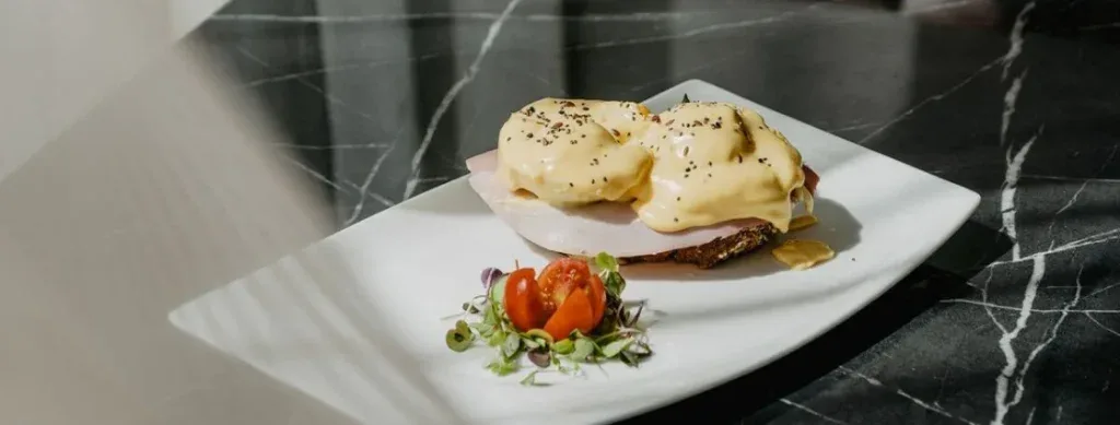 Representative hotel space: A plated meal with two poached eggs rests on a dark countertop.