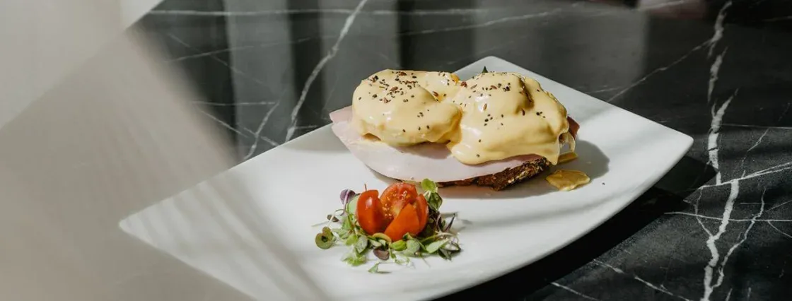 Representative hotel space: A plated breakfast sandwich topped with egg sits beside a small garnish.