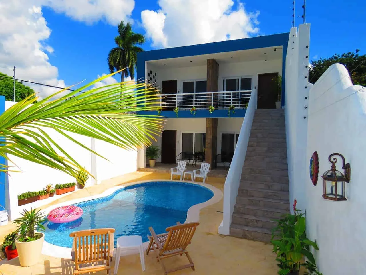 Representative hotel space: An outdoor pool beside a modern two-story building and patio seating.