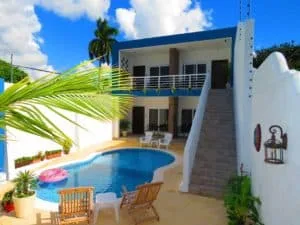 Representative hotel space: An outdoor pool and seating area sit beside a modern two-story building.