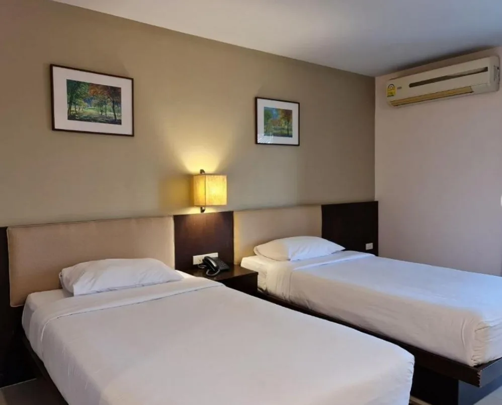 Representative hotel space: A hotel bedroom with two beds and a bedside lamp.