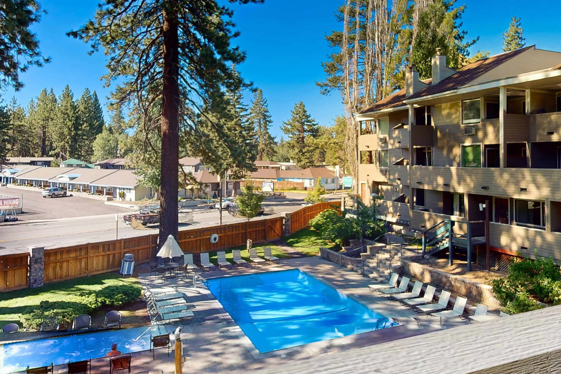 Shared amenity: Outdoor pool beside a multi-story building, with lounge seating along the deck.
