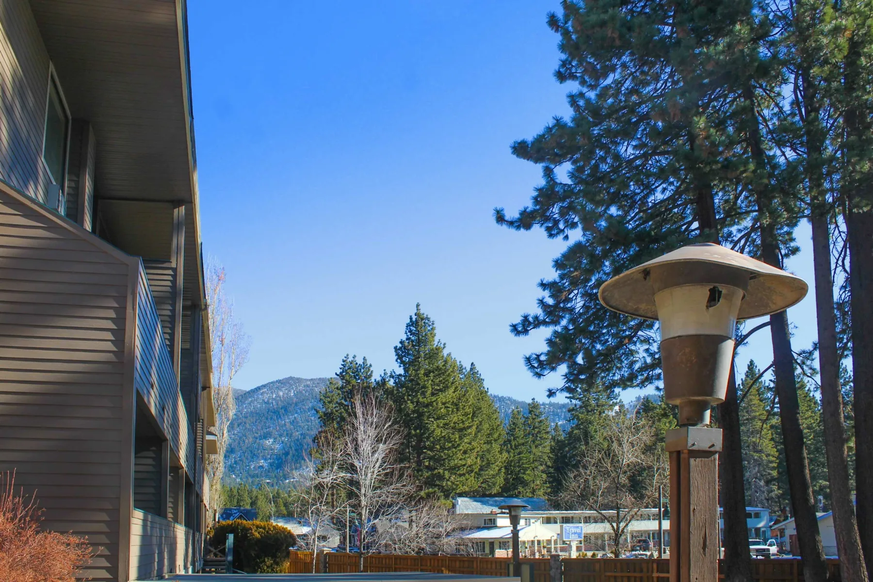 Shared amenity: Outdoor scene beside a building, with trees and mountains in the background.