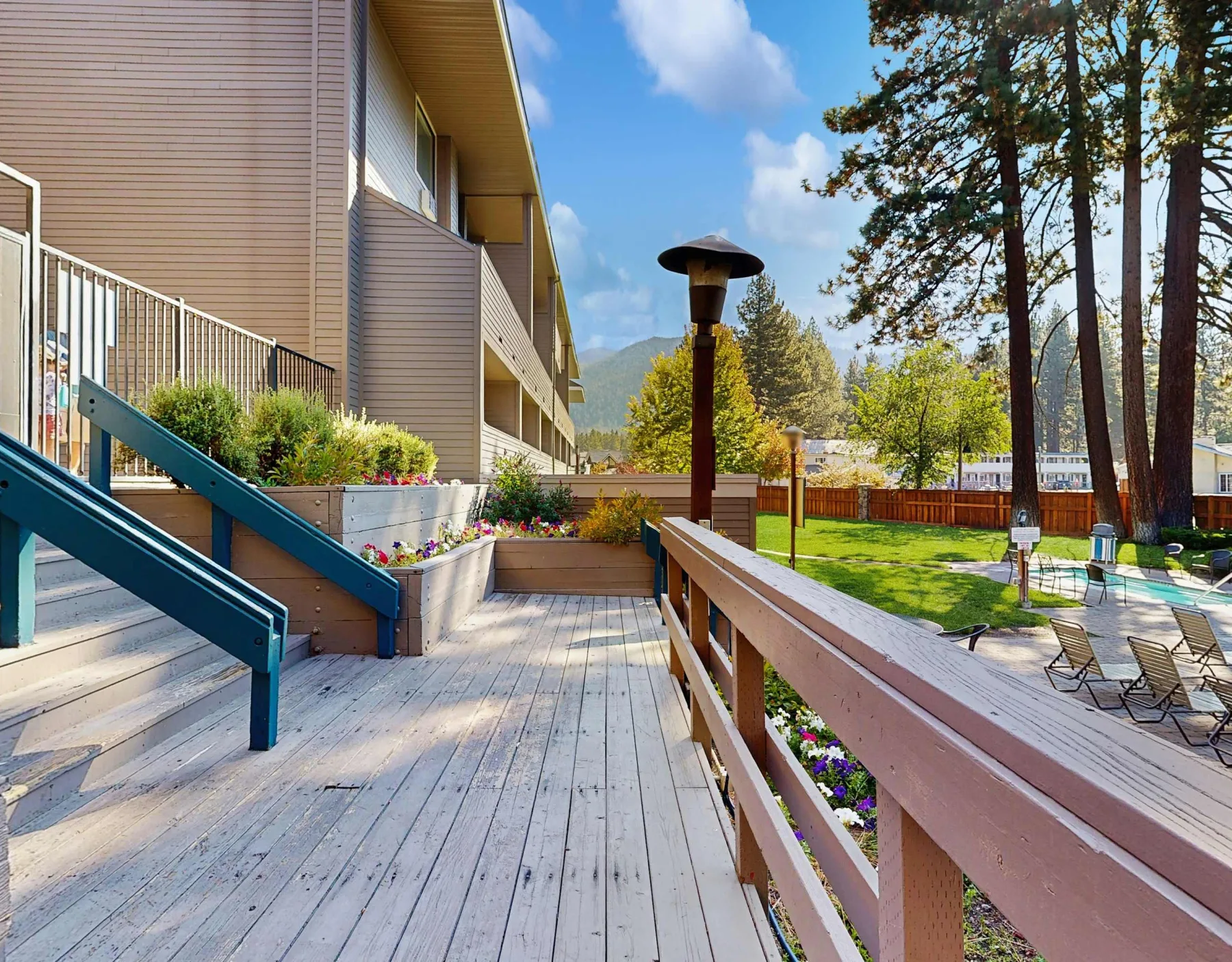 Shared amenity: Outdoor deck beside a building, with planters and a grassy seating area.