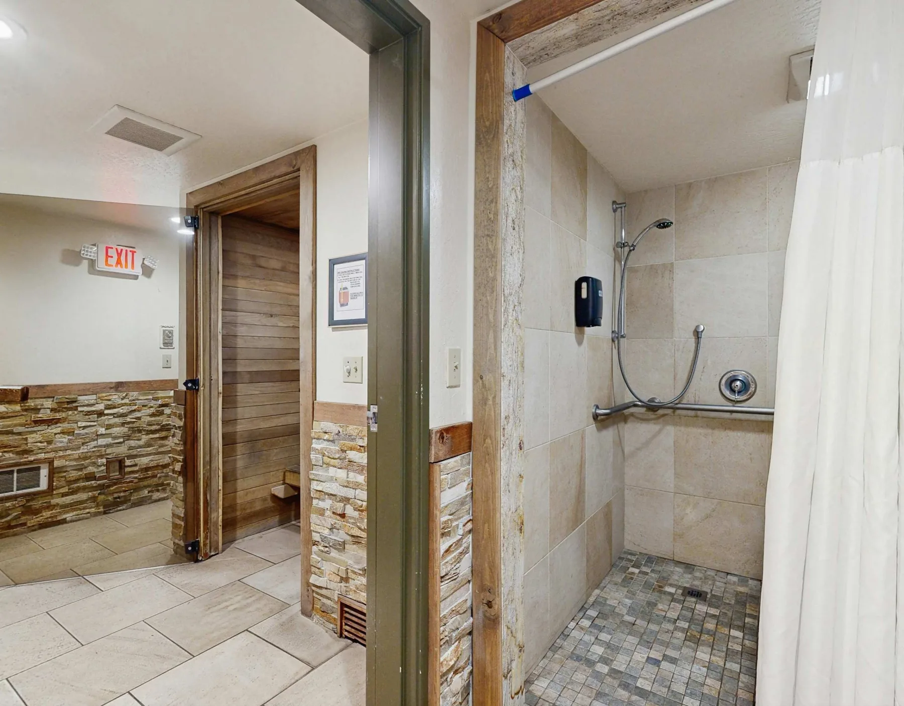 Shared amenity: Bathroom shower area beside a tiled hallway.