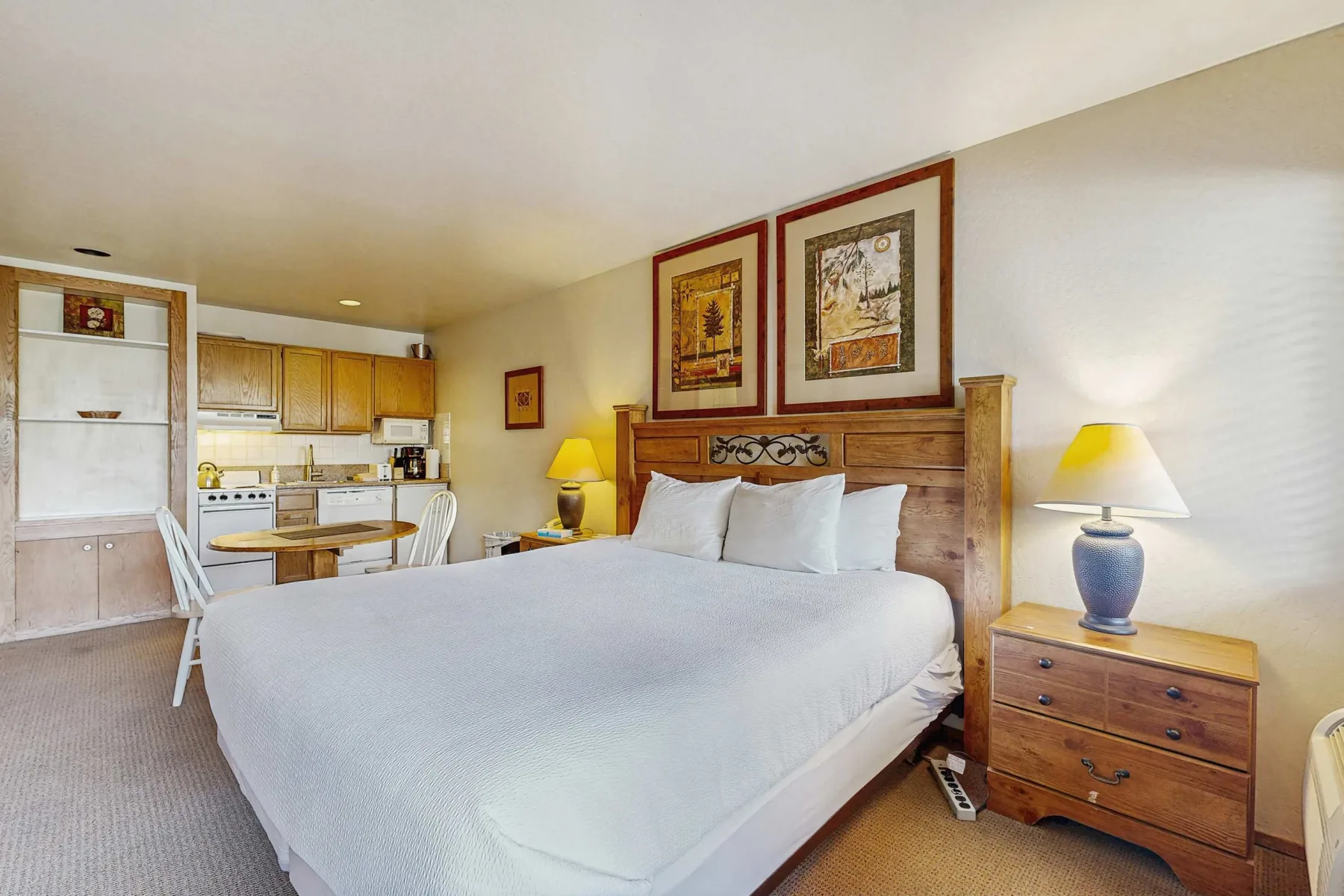 A bedroom with a large bed, wooden headboard, and bedside tables.