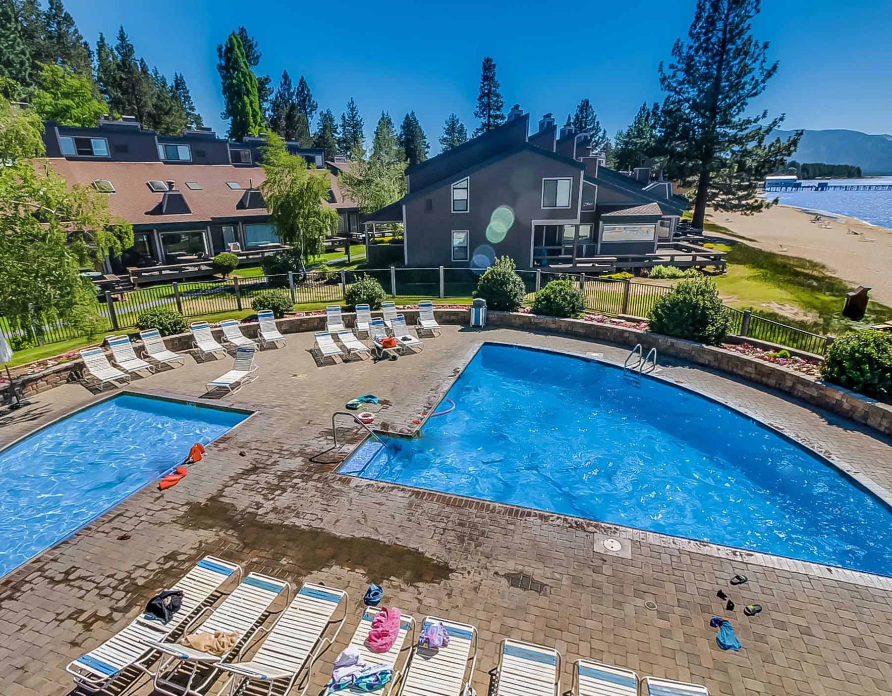 Shared amenity: An outdoor pool area with lounge seating beside a sandy beach.
