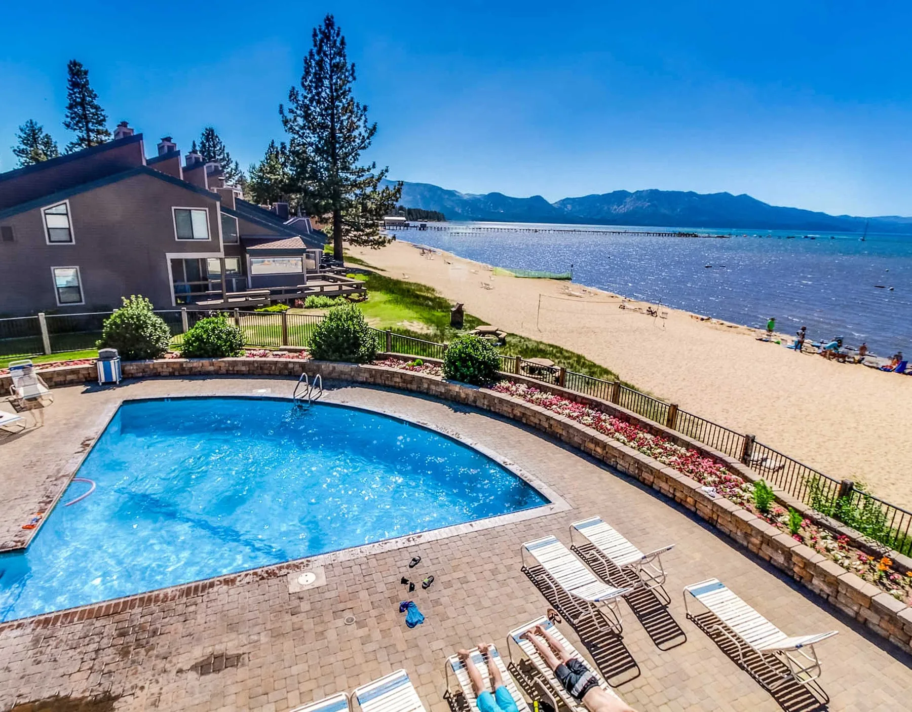 Shared amenity: A poolside patio overlooks a sandy beach and the lake.